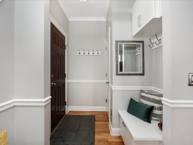 mudroom featuring crown molding, baseboards, and light wood-type flooring