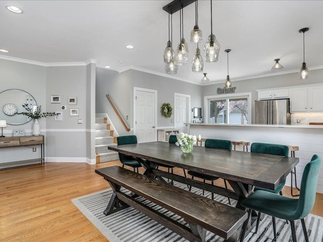 dining area with recessed lighting, baseboards, ornamental molding, and light wood-style floors