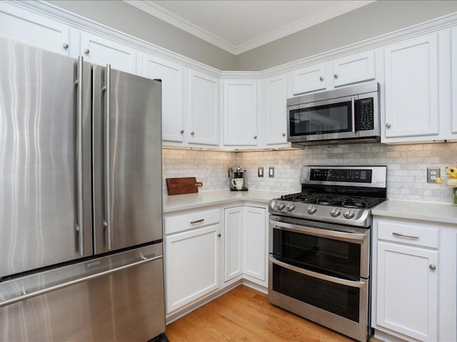 kitchen featuring backsplash, appliances with stainless steel finishes, light countertops, ornamental molding, and white cabinetry