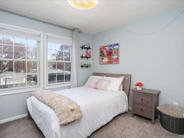 bedroom with baseboards and carpet