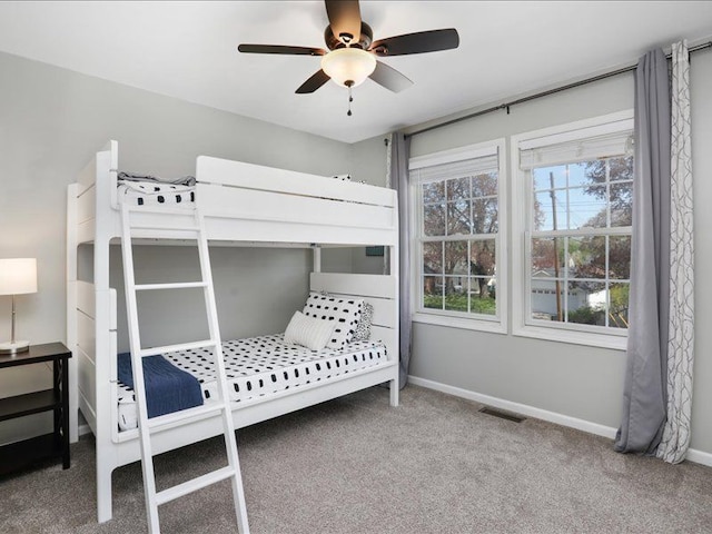 carpeted bedroom with baseboards, visible vents, and ceiling fan