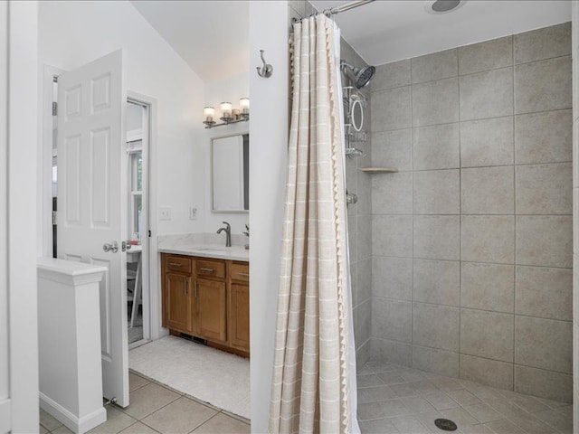 full bath with tile patterned floors, tiled shower, lofted ceiling, and vanity