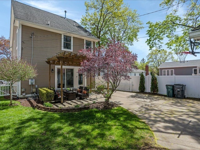 back of house featuring a yard, fence, and a pergola