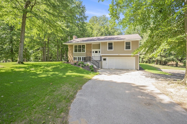 2908 Rennells Rd, Spring Lake, MI 49456 - split foyer home featuring asphalt driveway, a chimney, an attached garage, and a front yard