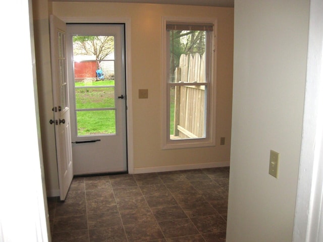 doorway featuring baseboards and plenty of natural light