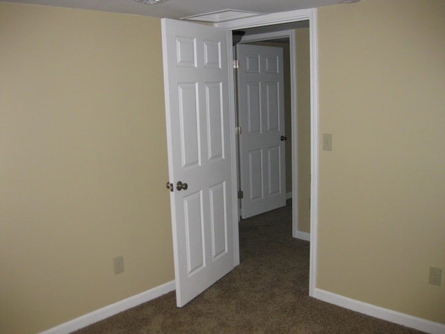 interior space with dark carpet and baseboards