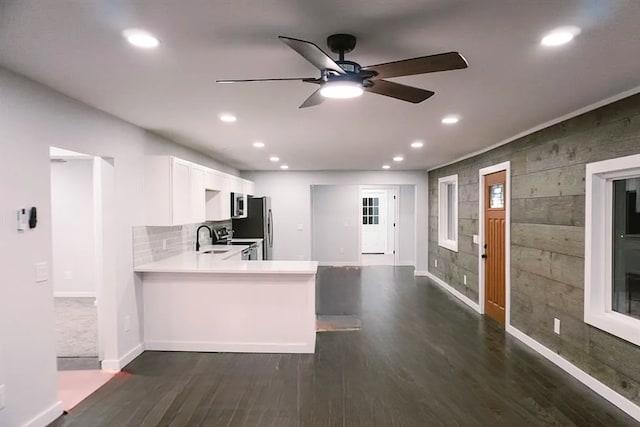 kitchen featuring a ceiling fan, a sink, light countertops, appliances with stainless steel finishes, and dark wood-style floors