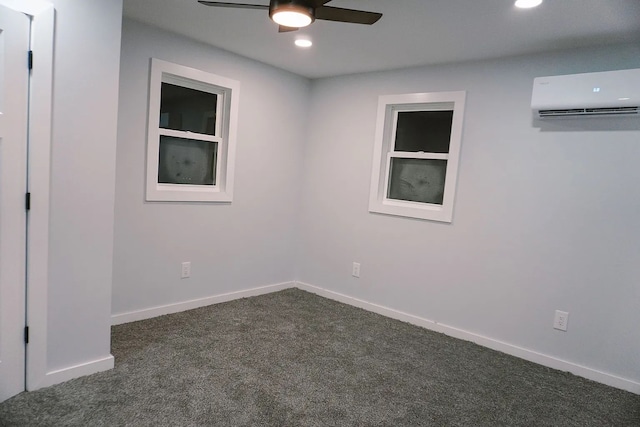 empty room with a ceiling fan, a wall mounted AC, dark carpet, baseboards, and recessed lighting