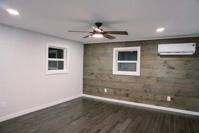 empty room featuring recessed lighting, ceiling fan, baseboards, a wall mounted AC, and dark wood-style flooring