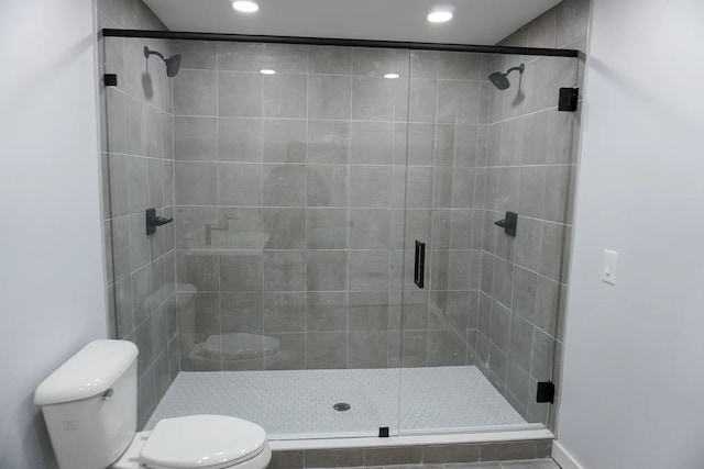 full bathroom with toilet, a stall shower, and recessed lighting