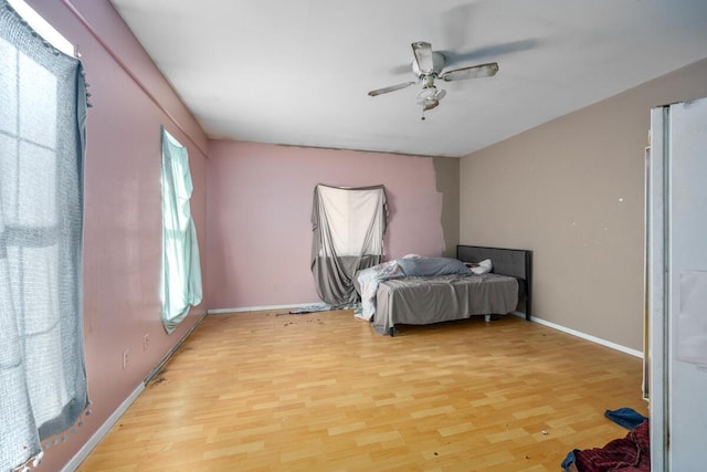 bedroom with ceiling fan, baseboards, and light wood-style floors