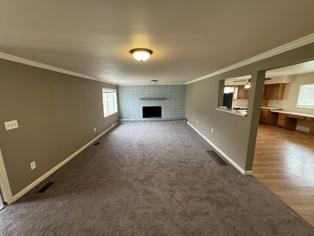 8066 Talladay Rd, Whittaker, MI 48190 - unfurnished living room with a fireplace, visible vents, a wealth of natural light, and ornamental molding