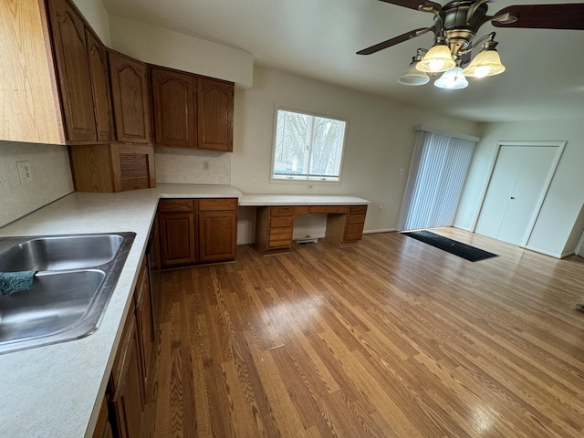 8066 Talladay Rd, Whittaker, MI 48190 - kitchen with wood finished floors, light countertops, a ceiling fan, and built in desk