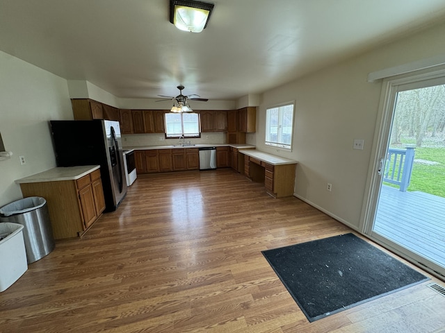 8066 Talladay Rd, Whittaker, MI 48190 - kitchen with a sink, wood finished floors, ceiling fan, light countertops, and appliances with stainless steel finishes