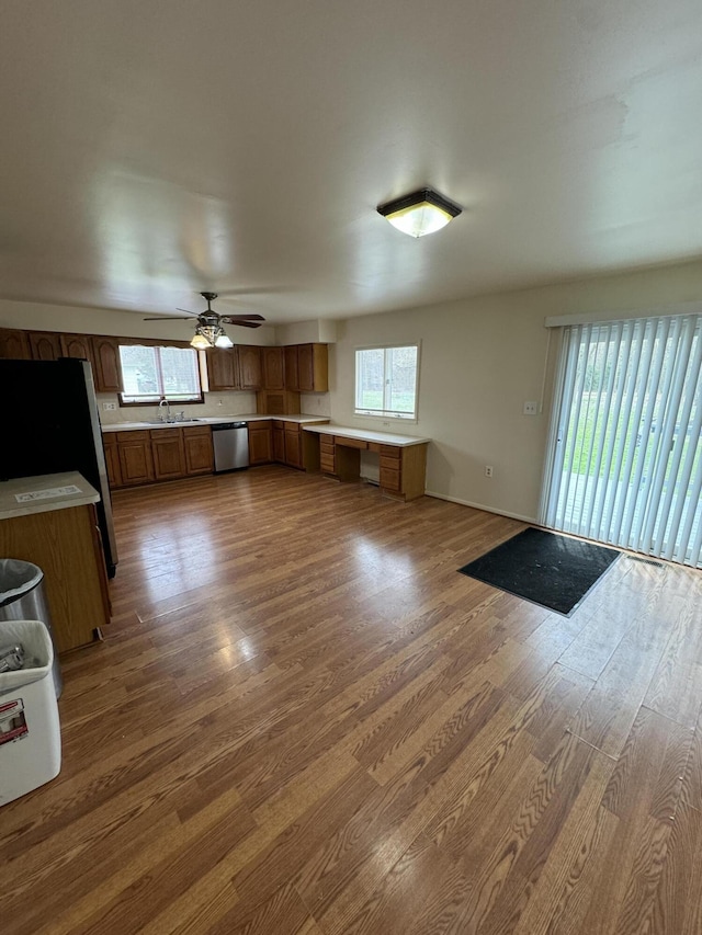 8066 Talladay Rd, Whittaker, MI 48190 - kitchen with brown cabinets, wood finished floors, a wealth of natural light, and appliances with stainless steel finishes