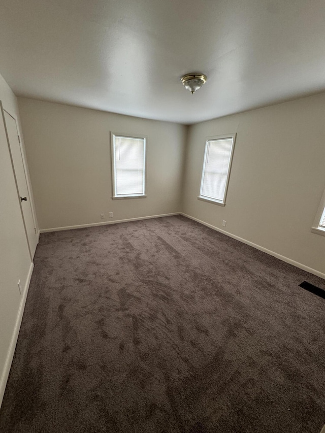 8066 Talladay Rd, Whittaker, MI 48190 - unfurnished bedroom with carpet floors, multiple windows, visible vents, and baseboards