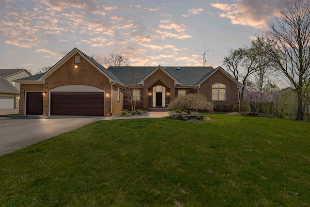 view of front of home with a front lawn, driveway, a garage, and brick siding