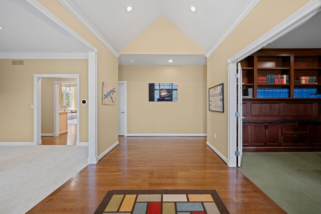 hallway featuring crown molding, lofted ceiling, and wood finished floors