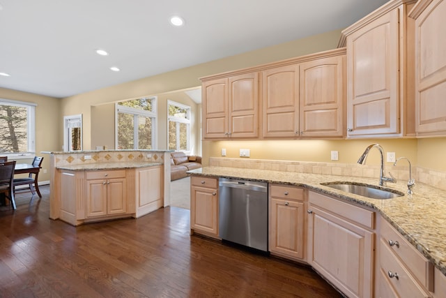 kitchen with light brown cabinets, dishwasher, and a sink
