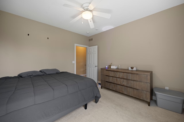 bedroom featuring a ceiling fan, visible vents, and light colored carpet