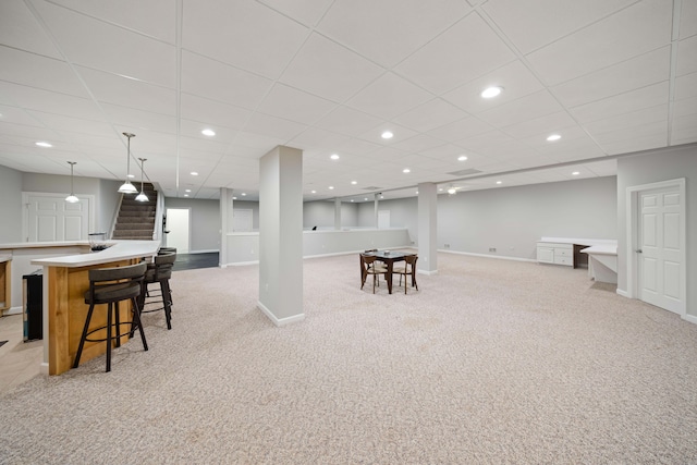 interior space with baseboards, a bar, recessed lighting, and light carpet