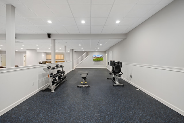 exercise room with baseboards, recessed lighting, and a paneled ceiling