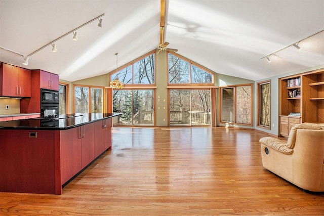 kitchen with light wood-type flooring, rail lighting, open floor plan, and black appliances