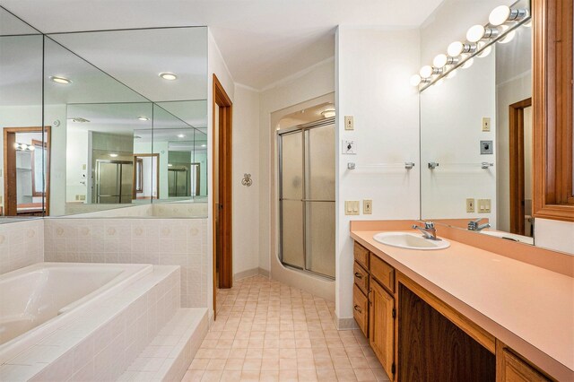 bathroom featuring a shower stall, tile patterned flooring, vanity, baseboards, and a garden tub