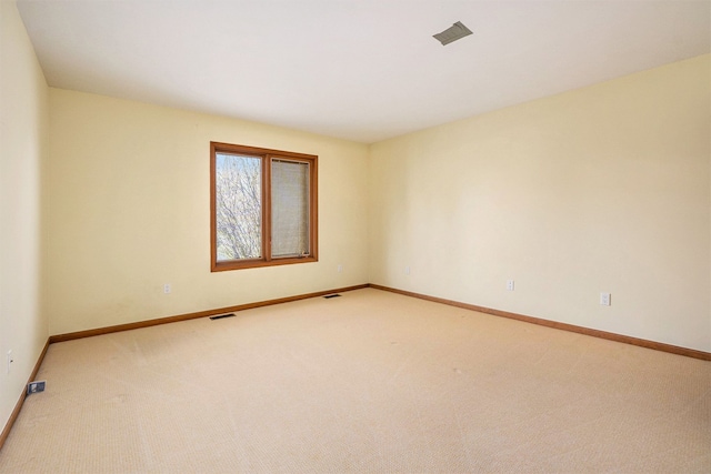 empty room with visible vents, baseboards, and light colored carpet