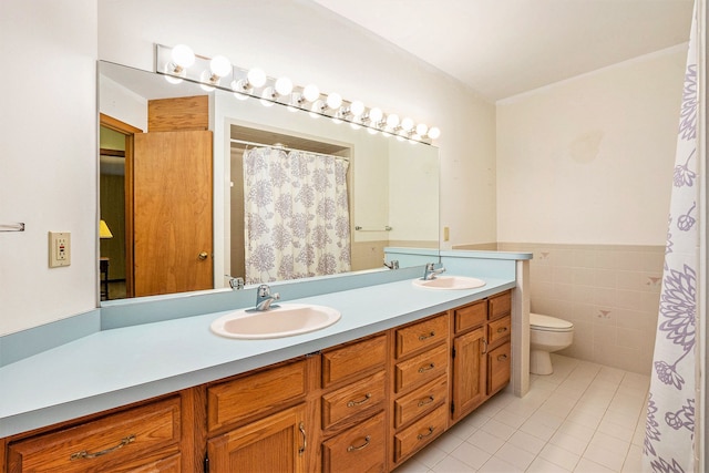 full bath with tile patterned floors, a sink, double vanity, and toilet