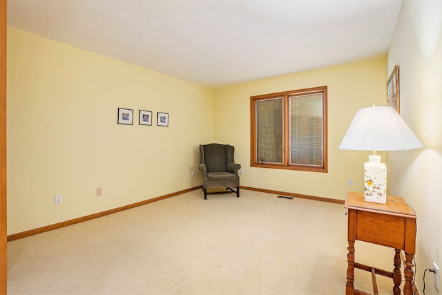sitting room featuring visible vents, carpet flooring, and baseboards