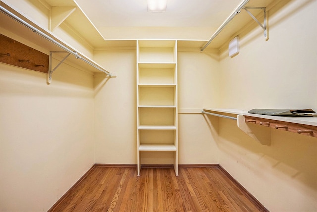 walk in closet with wood finished floors