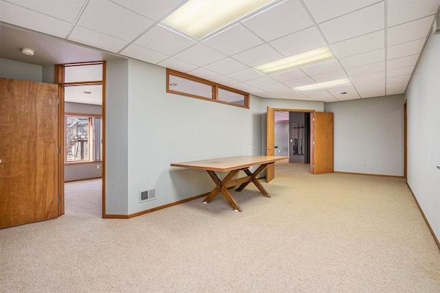 interior space with a paneled ceiling, baseboards, visible vents, and carpet