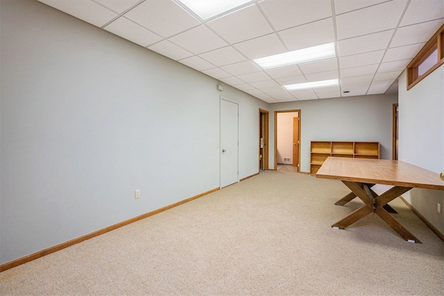 interior space featuring carpet flooring, baseboards, and a drop ceiling