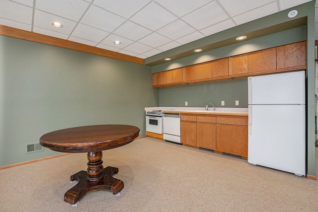 kitchen with light countertops, visible vents, white appliances, baseboards, and a paneled ceiling