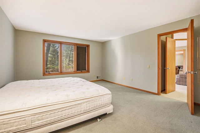 bedroom with baseboards and light colored carpet