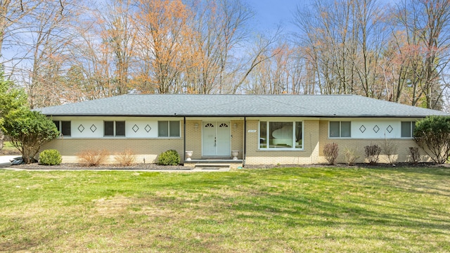 single story home with brick siding, a front yard, and roof with shingles