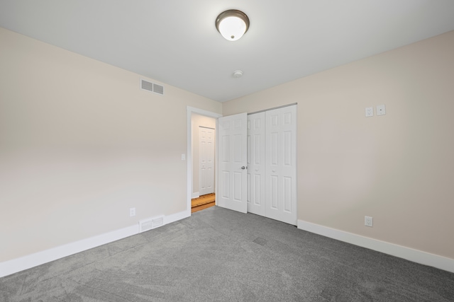 unfurnished bedroom with visible vents, carpet, baseboards, and a closet