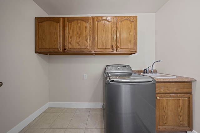 laundry area with cabinet space, light tile patterned floors, baseboards, a sink, and washer / dryer