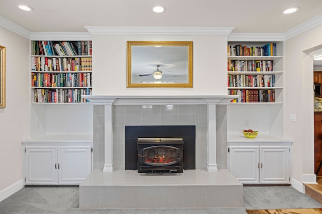 interior space with baseboards, ornamental molding, a ceiling fan, and built in shelves