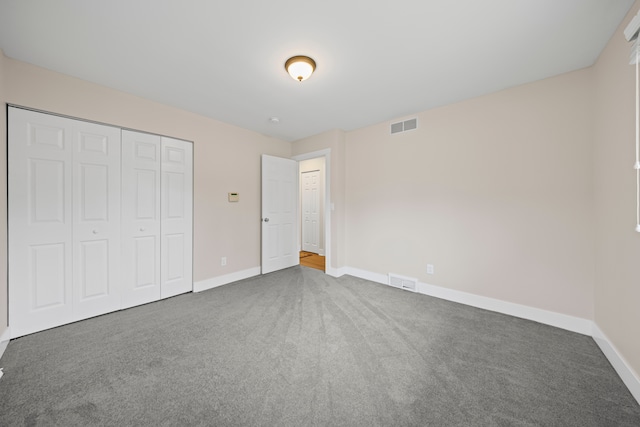 unfurnished bedroom featuring carpet floors, baseboards, and visible vents
