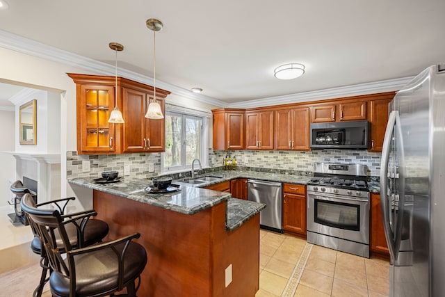 kitchen featuring decorative backsplash, a peninsula, a sink, appliances with stainless steel finishes, and light tile patterned floors