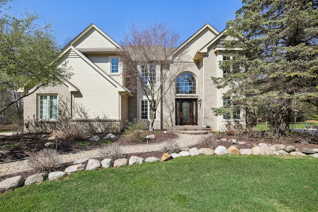 traditional home with brick siding and a front yard