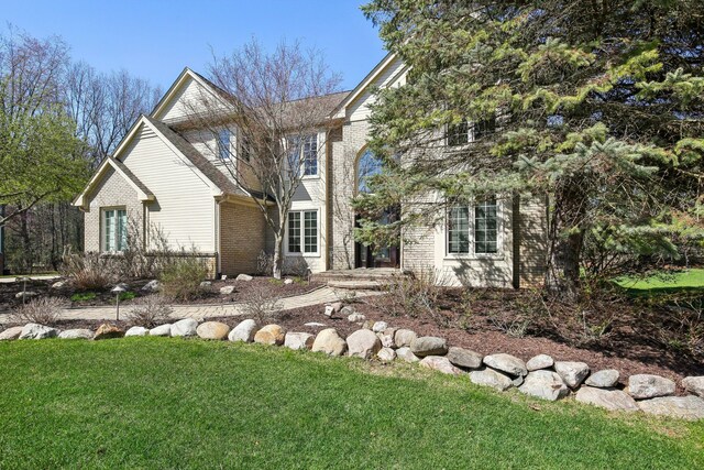 view of front of property featuring brick siding and a front lawn