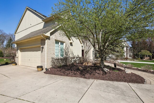 view of property exterior with concrete driveway, brick siding, and a garage