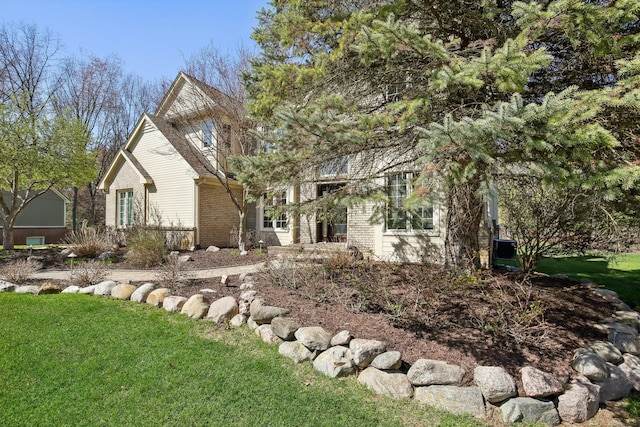 exterior space featuring brick siding and a front lawn