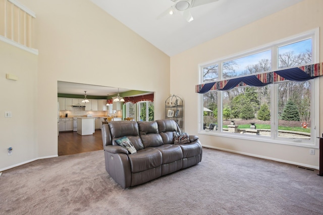 living room with carpet floors, visible vents, baseboards, ceiling fan, and high vaulted ceiling