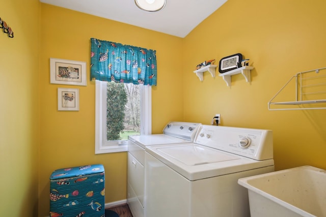 clothes washing area with washing machine and clothes dryer, laundry area, and a sink