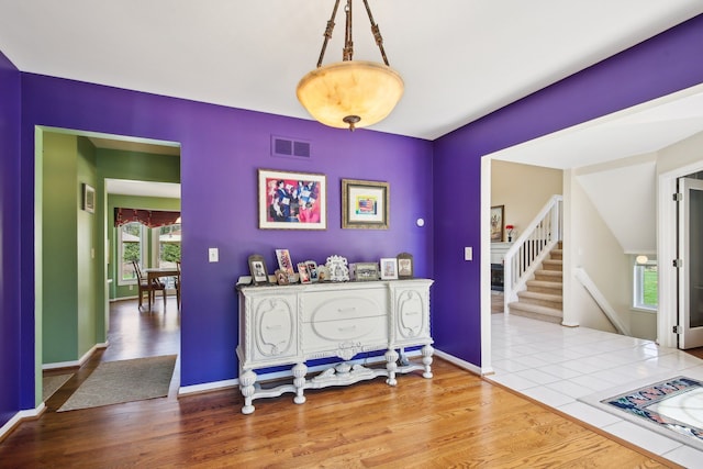 entryway featuring stairs, baseboards, visible vents, and wood finished floors