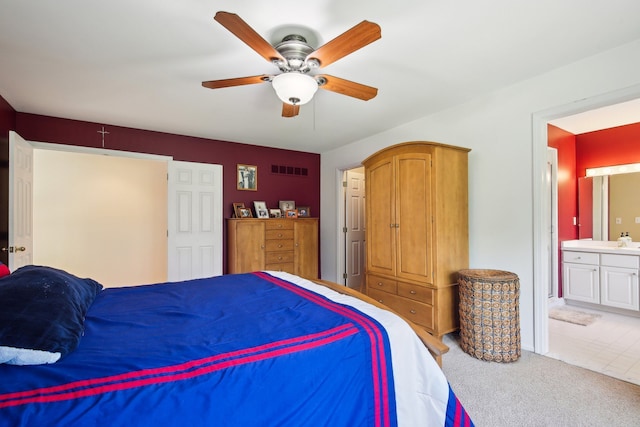 carpeted bedroom featuring connected bathroom, a ceiling fan, and visible vents
